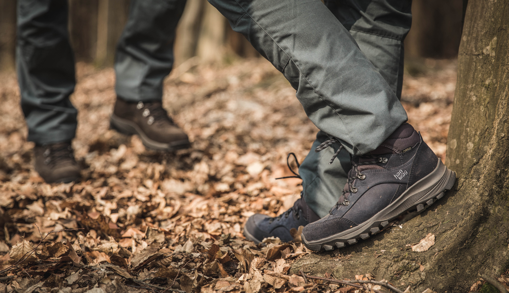 twee mensen op hanwag wandelschoenen staan in gevallen herfstbladeren