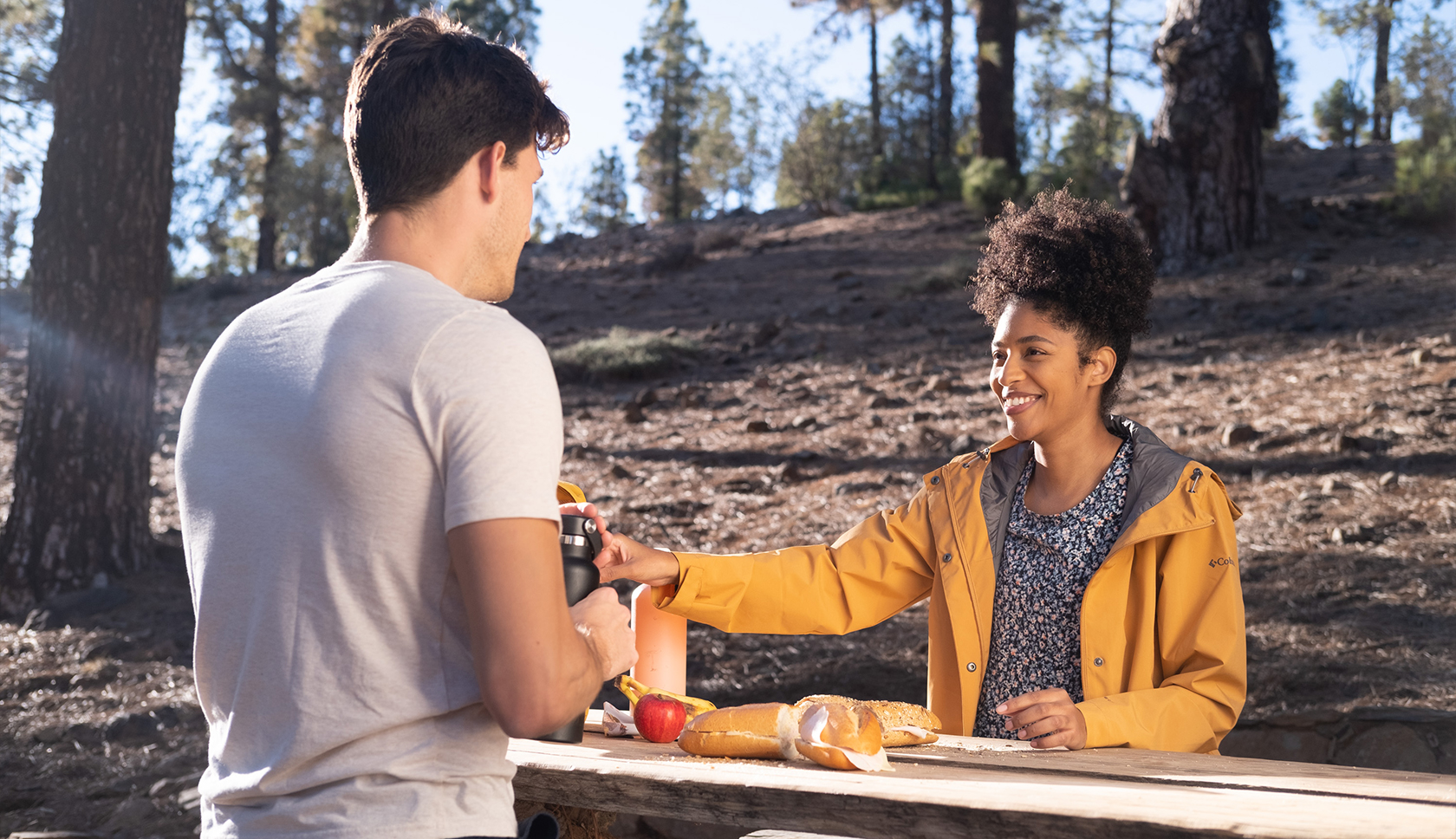 man en vrouw aan picknicktafel met waterflessen