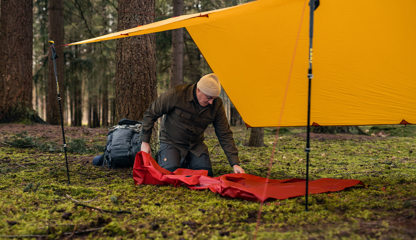 bushcrafter zet tarp en slaapmat op