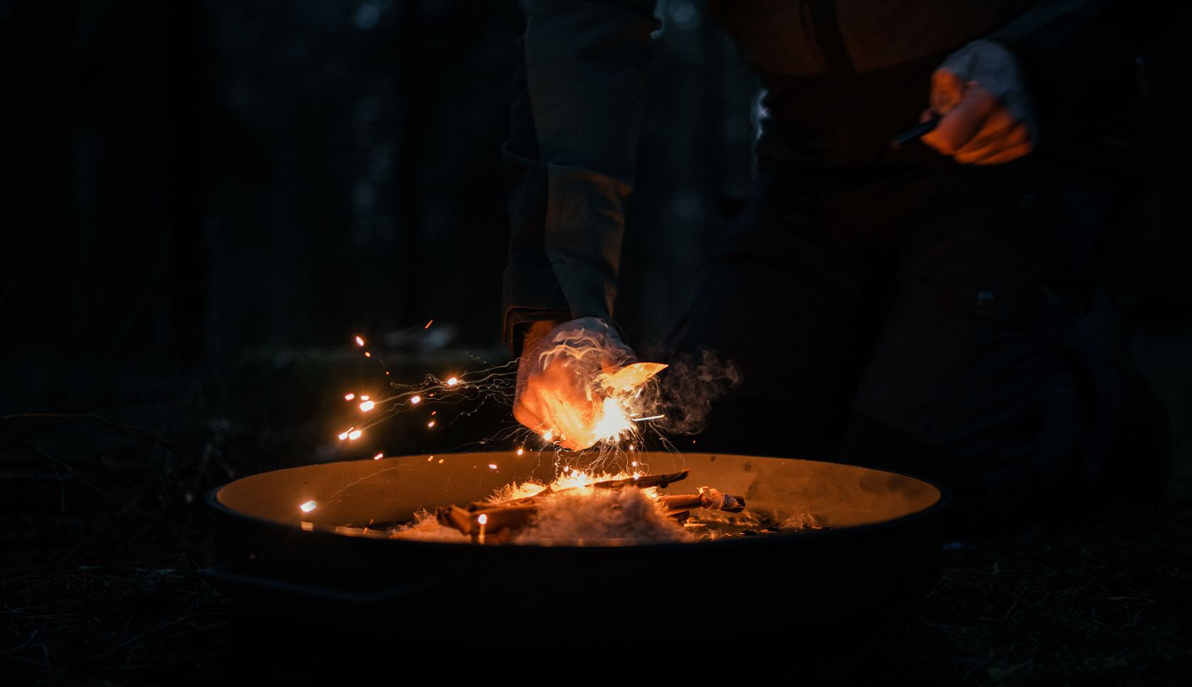 bushcrafter maakt vuur met firestarter