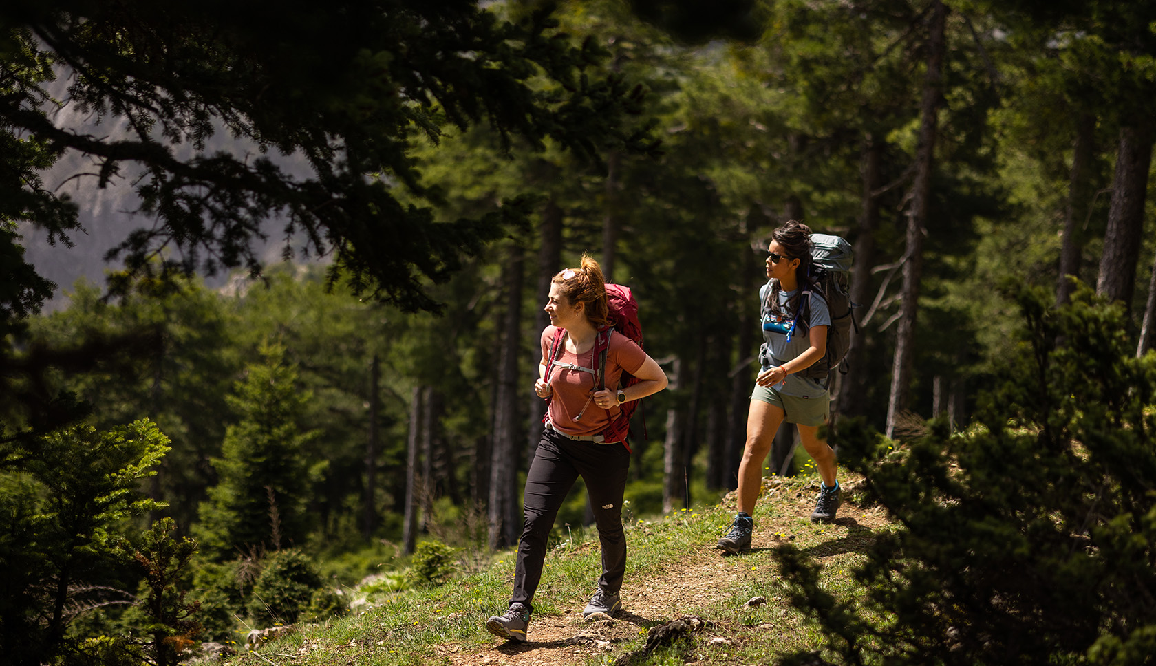 twee vrouwen lopen door bergen met merino wollen kleding