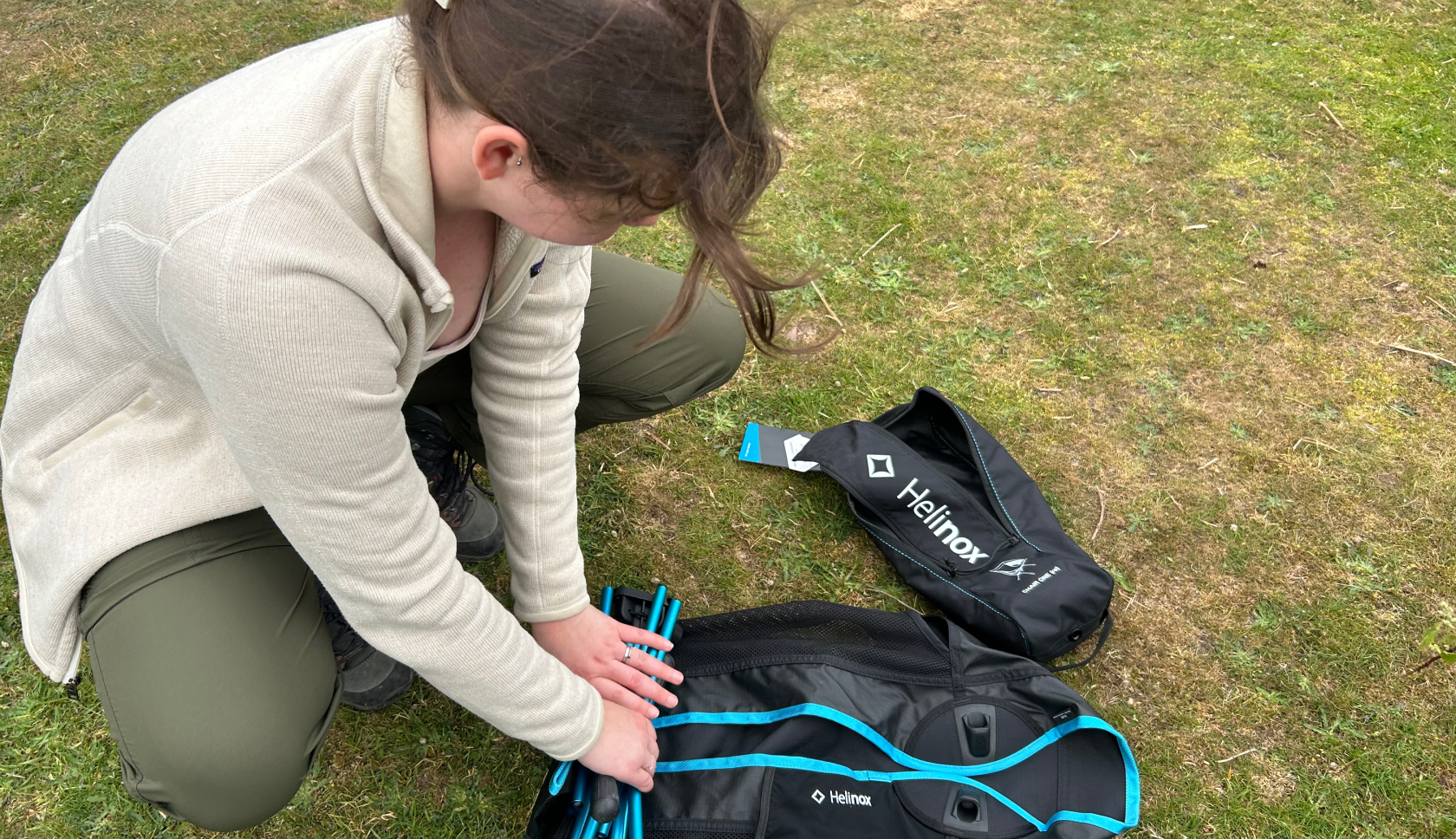 Een vrouw vouwt een campingstoel op.
