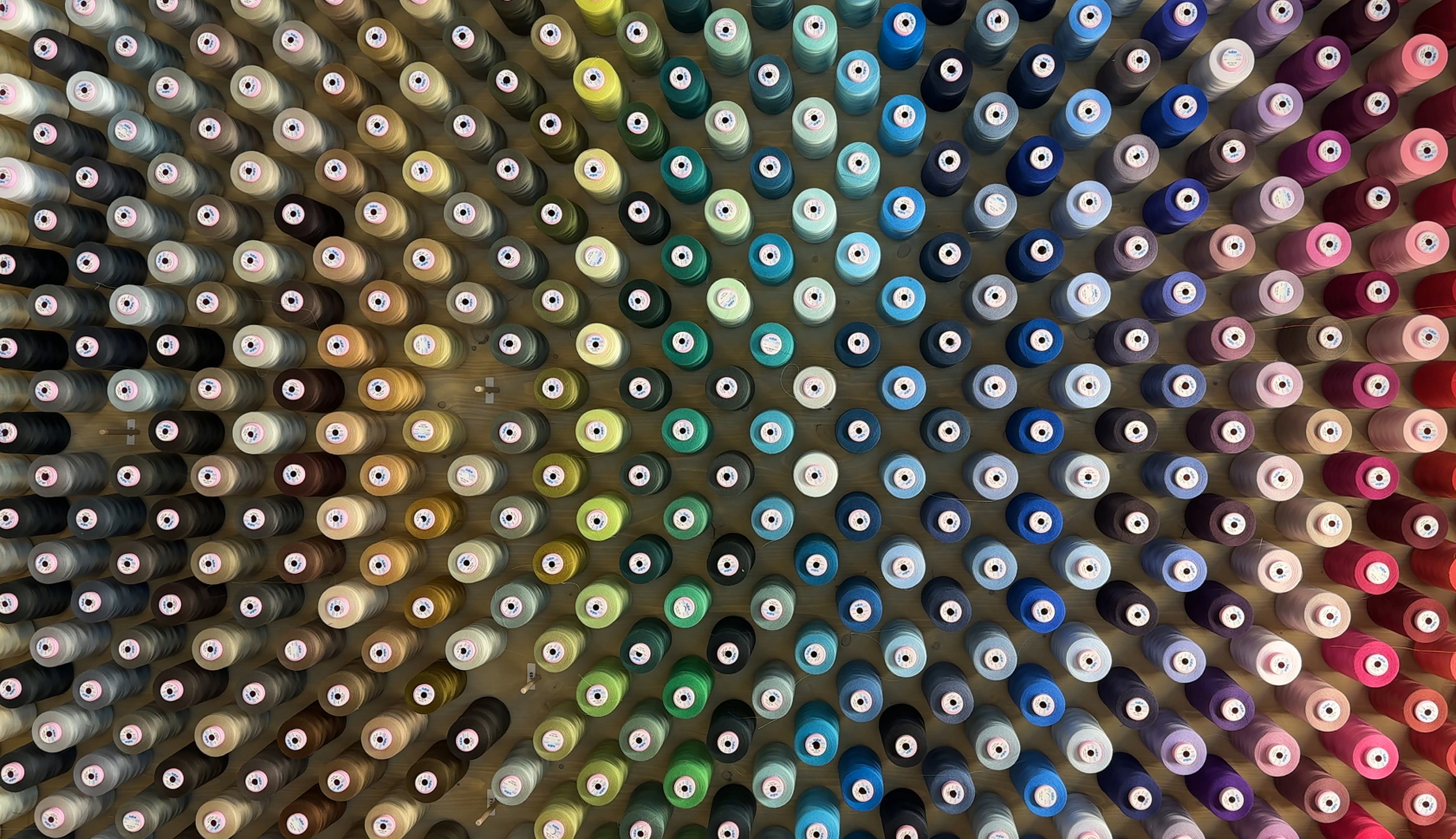 Verschillende klossen garen aan de wand