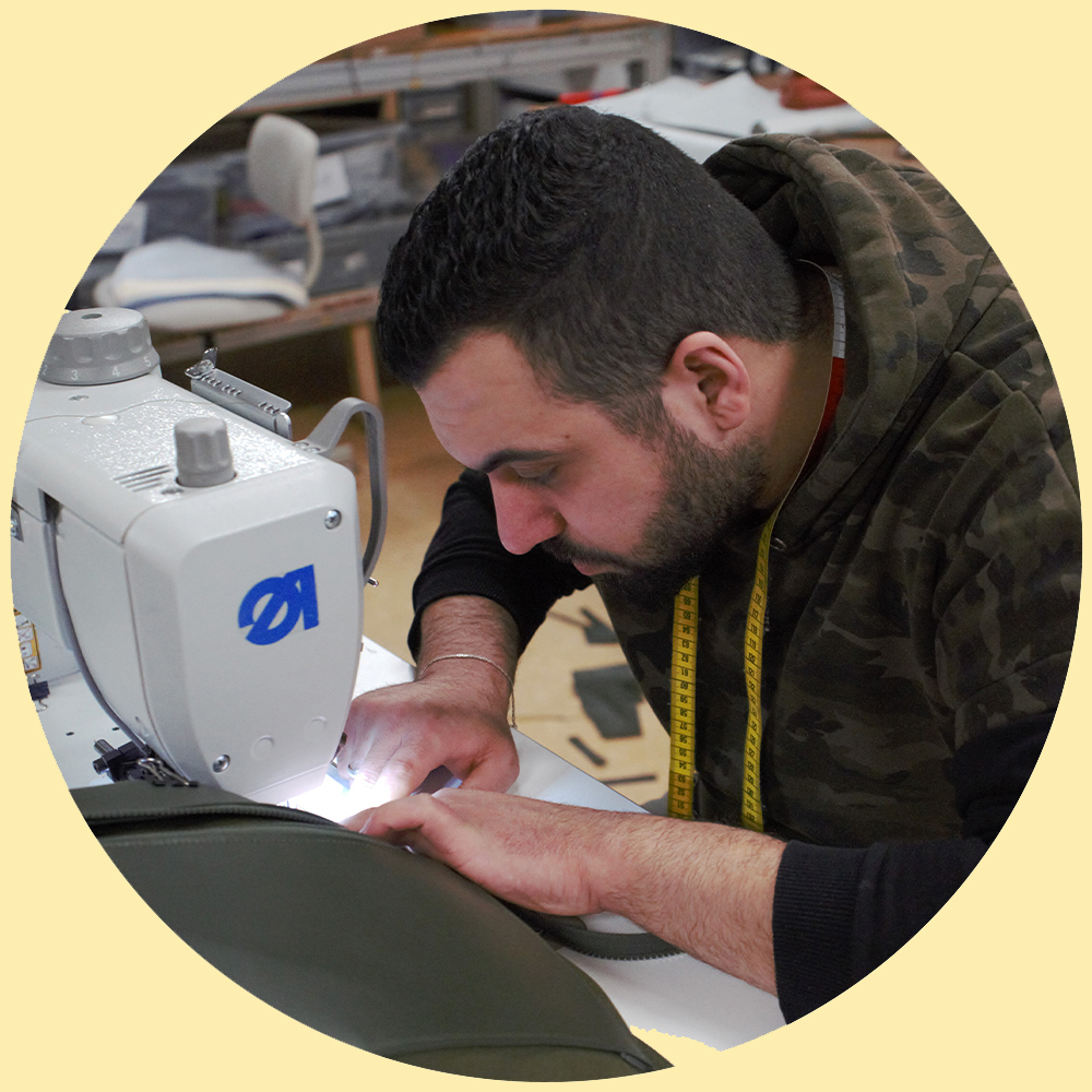Mo, medewerker in atelier Fraenck, werkt met een naaimachine aan Buitenmens-reisaccessoires 