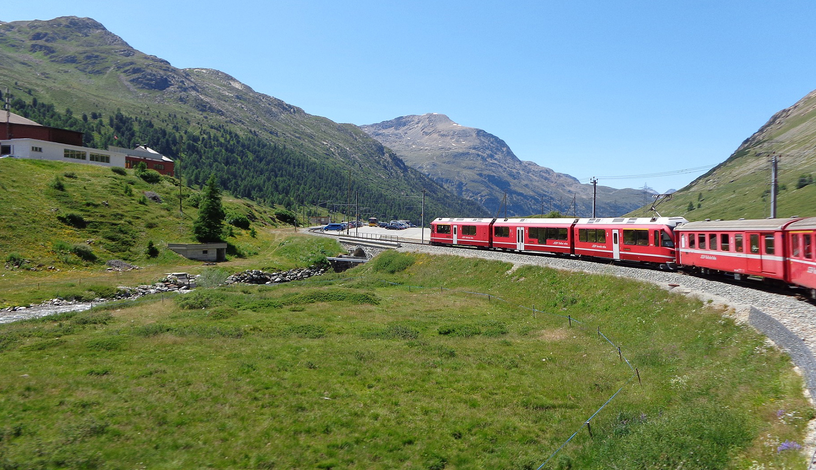 Rode trein rijdt door groen berggebied
