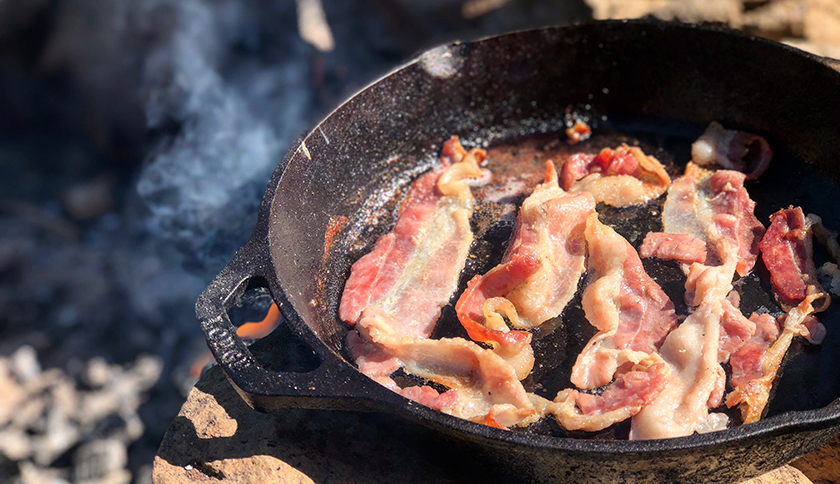 bacon wordt gebakken in een gietijzeren pan