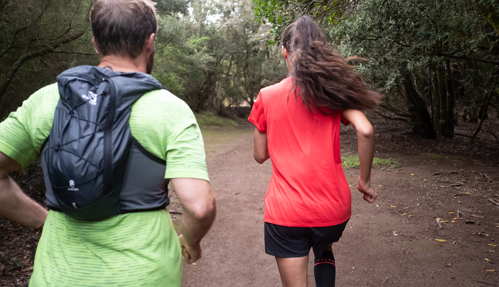 man en vrouw in gekleurde kleding trailrunnen