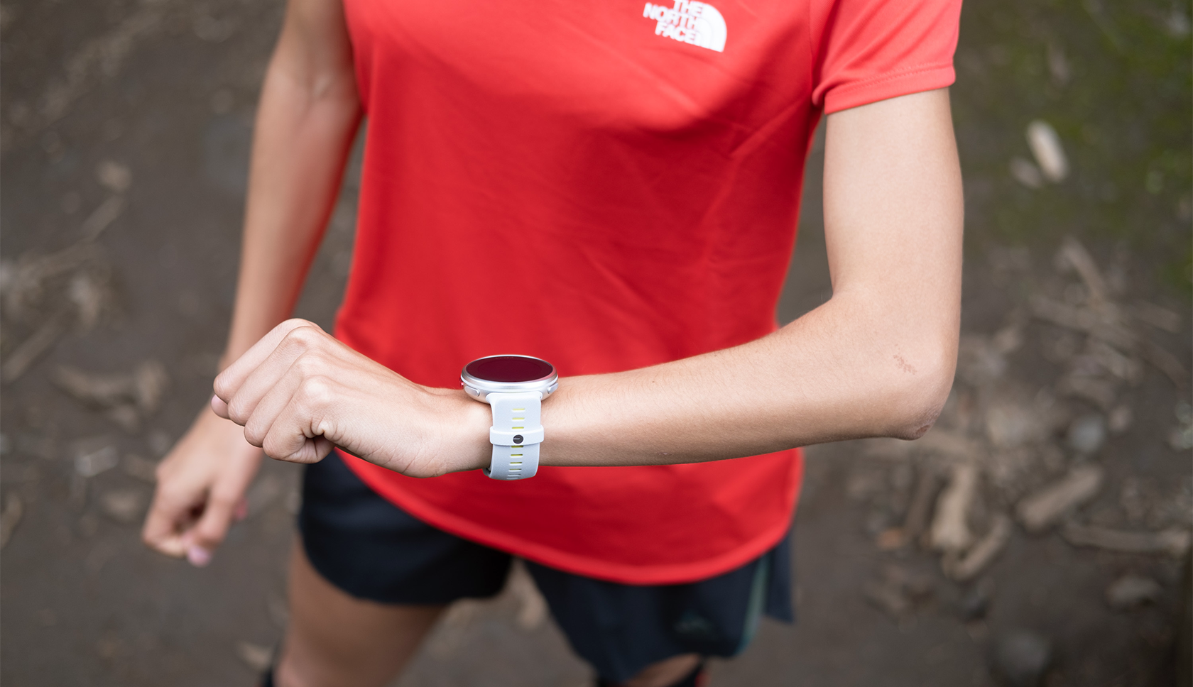 vrouw gebeurt sporthorloge tijdens trailrunnen