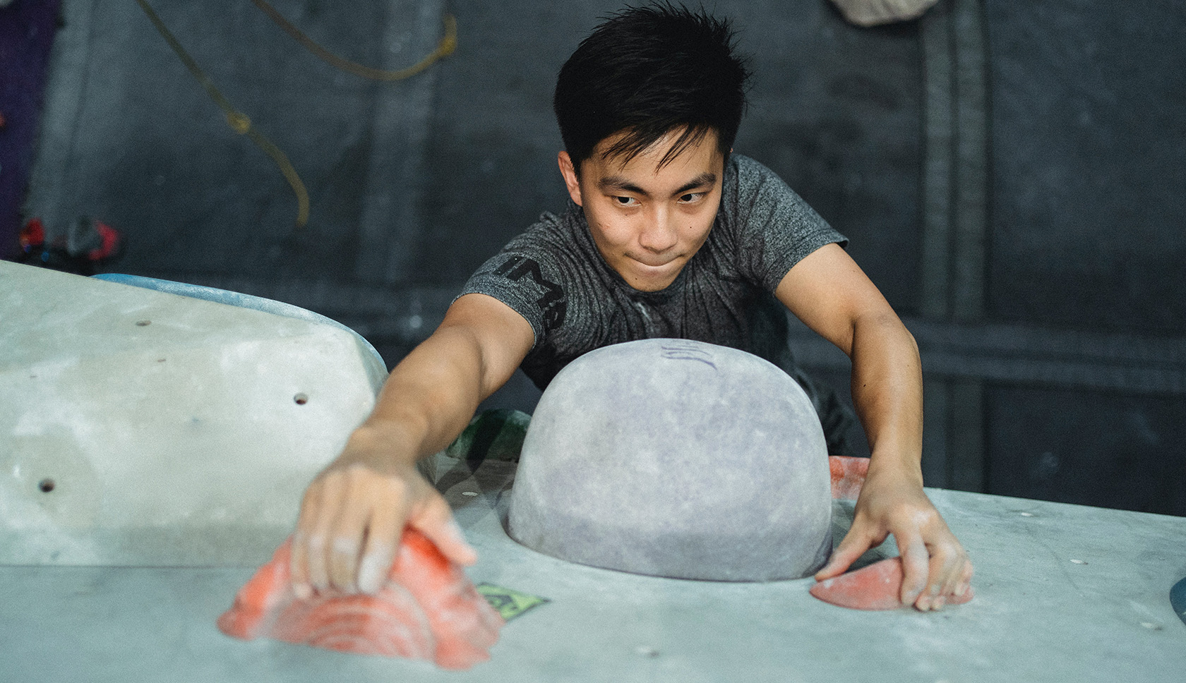 jongen klimt omhoog op bouldermuur 