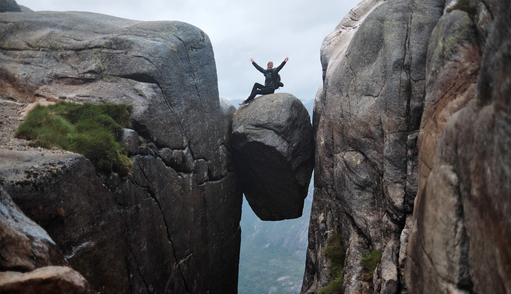 vrouw zit op trolltunga rots