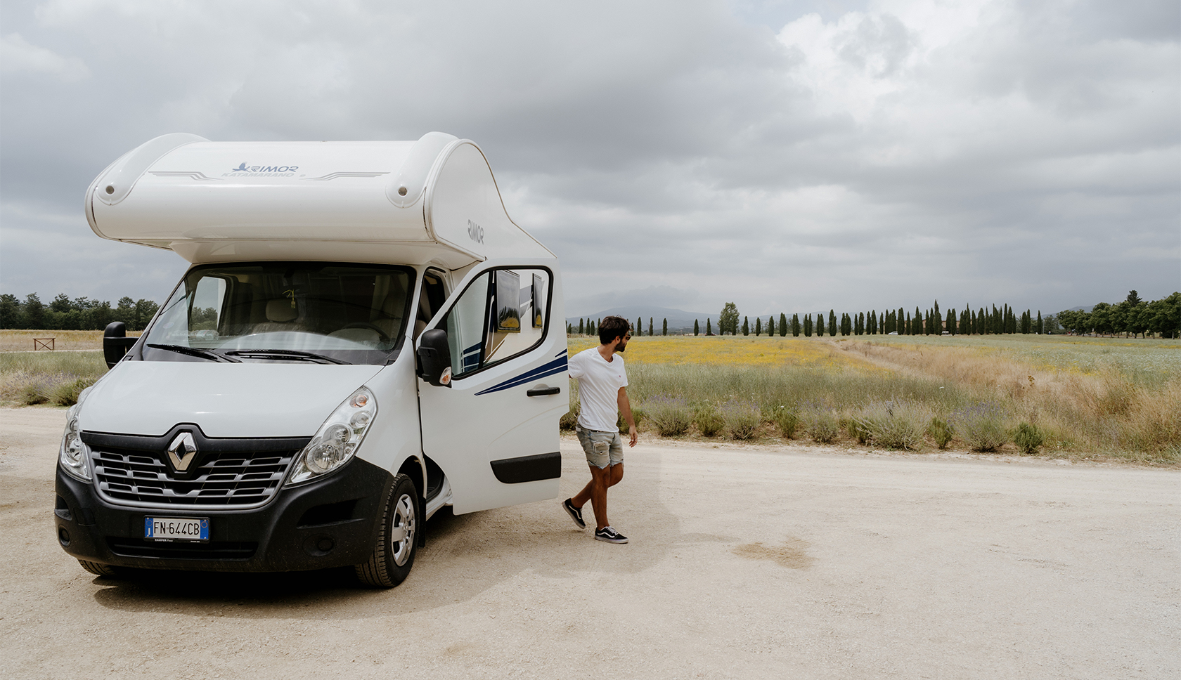 man stapt uit camper in italie