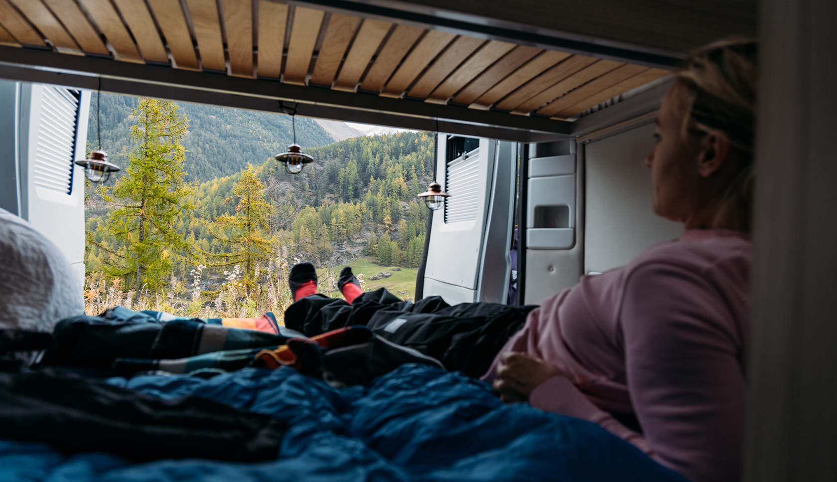 vrouw ligt in de camper en geniet van het uitzicht 