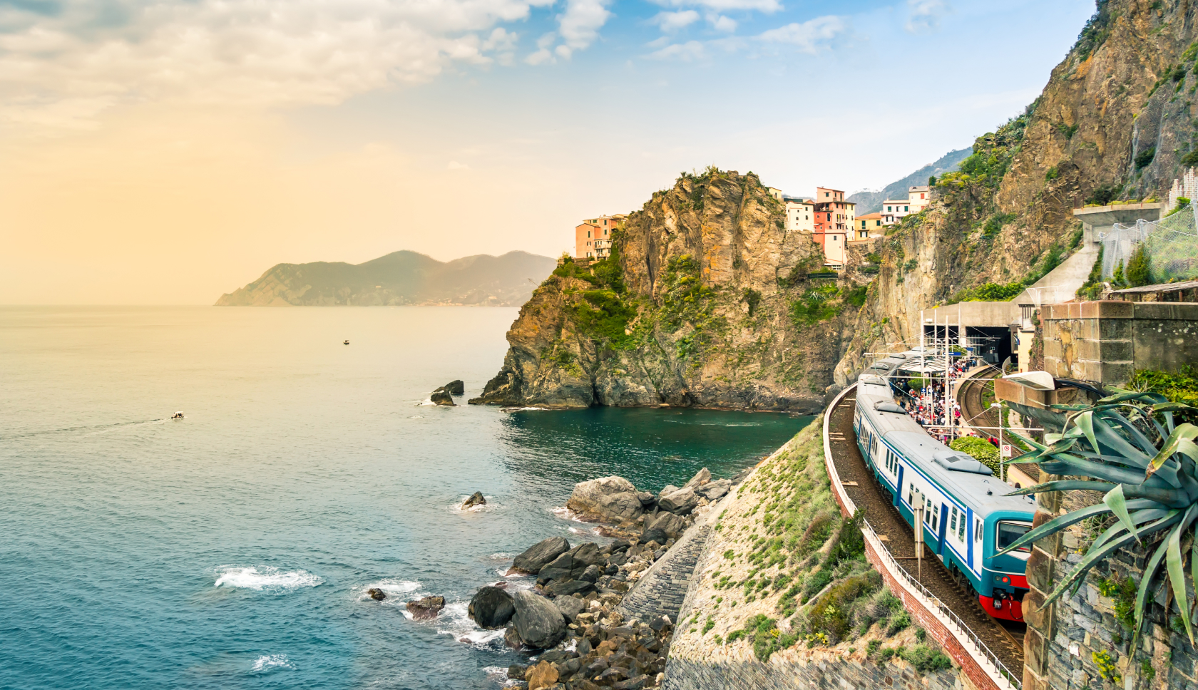 Een trein rijdt langs hoge kliffen in Cinque Terre