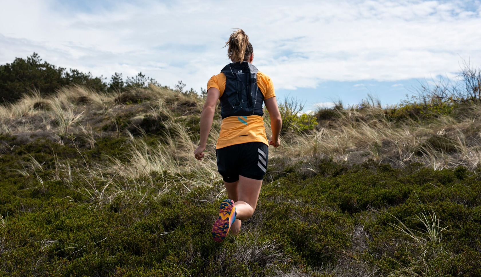 Een vrouw rent in de duinen