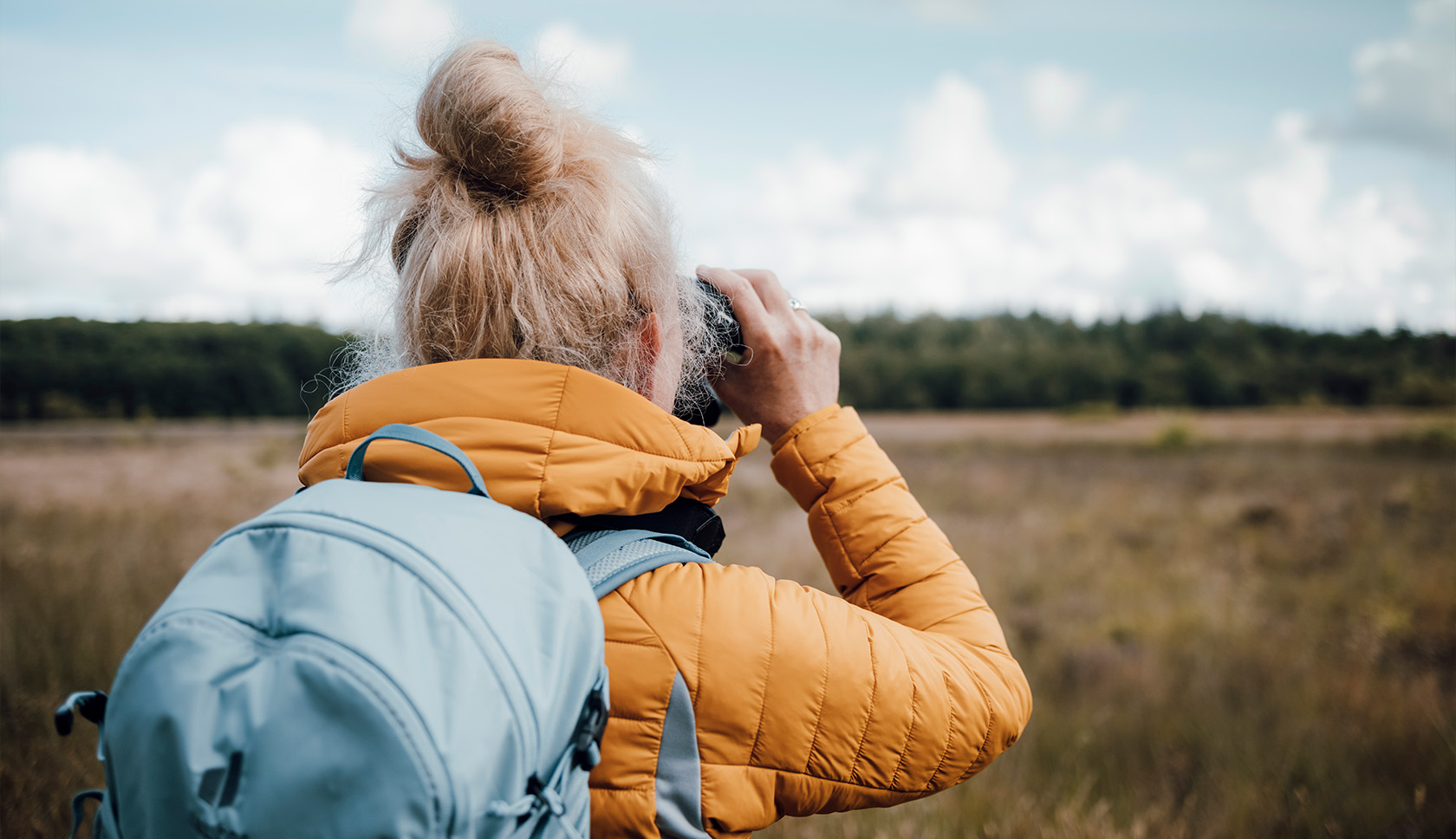 vrouw met verrekijker zoekt naar vogels