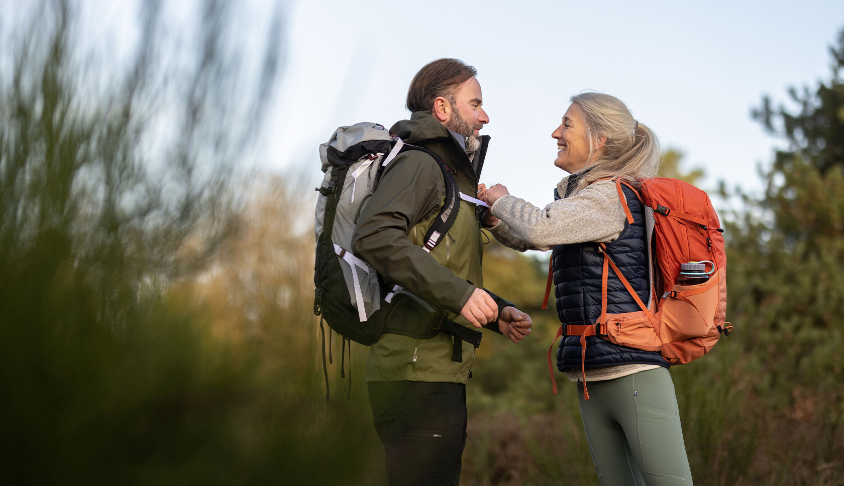 vrouw verstelt rugtas van man 