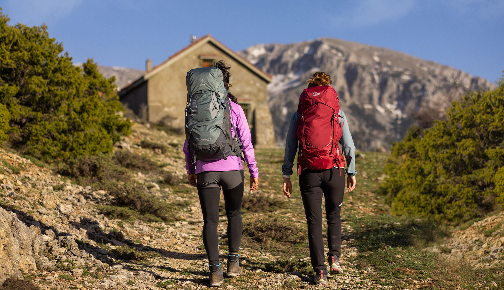 twee vrouwen met backpack lopen naar de hut toe 