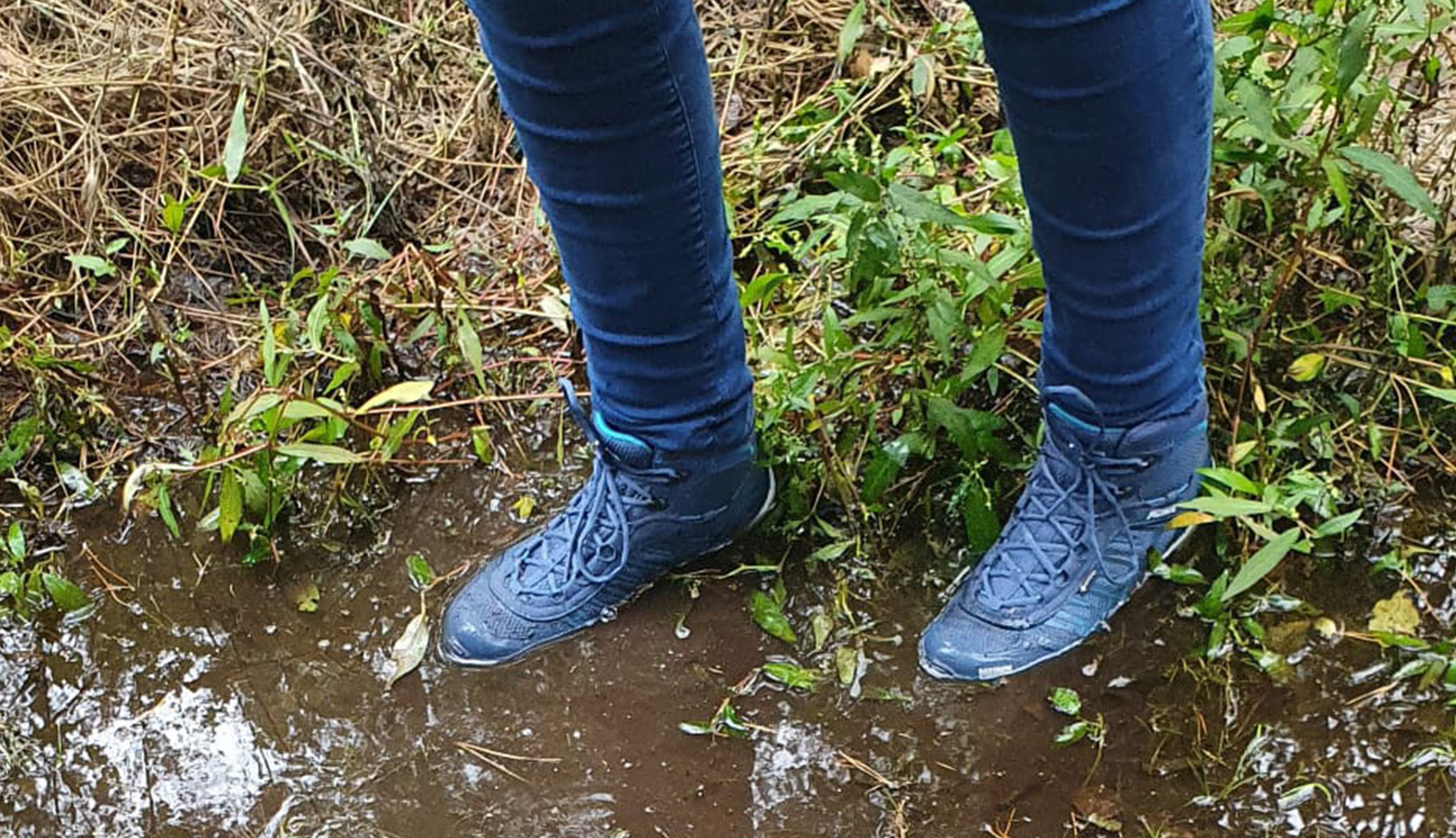 meindl wandelschoenen staan in een plas modderig water