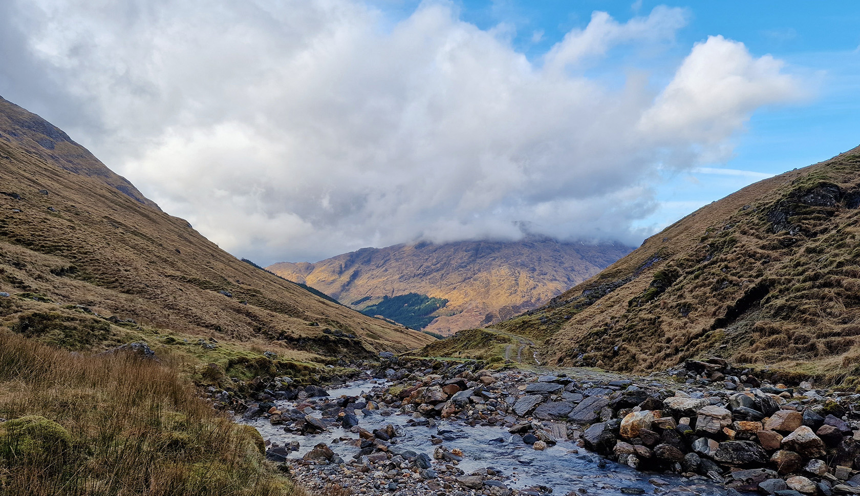 een beekje tussen twee bergen met prachtig uitzicht op bergachtig gebied