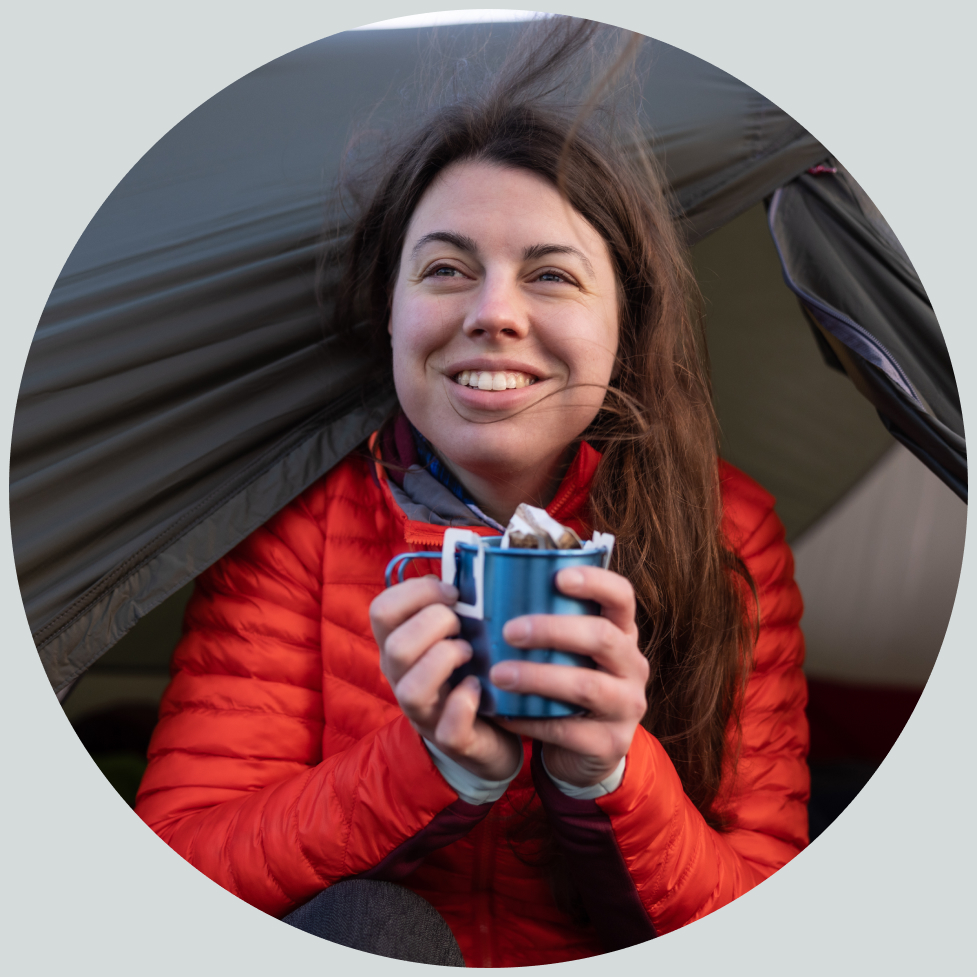 Buitenexpert Lisanne draagt een blauwe hardshell en icebreaker-pet 