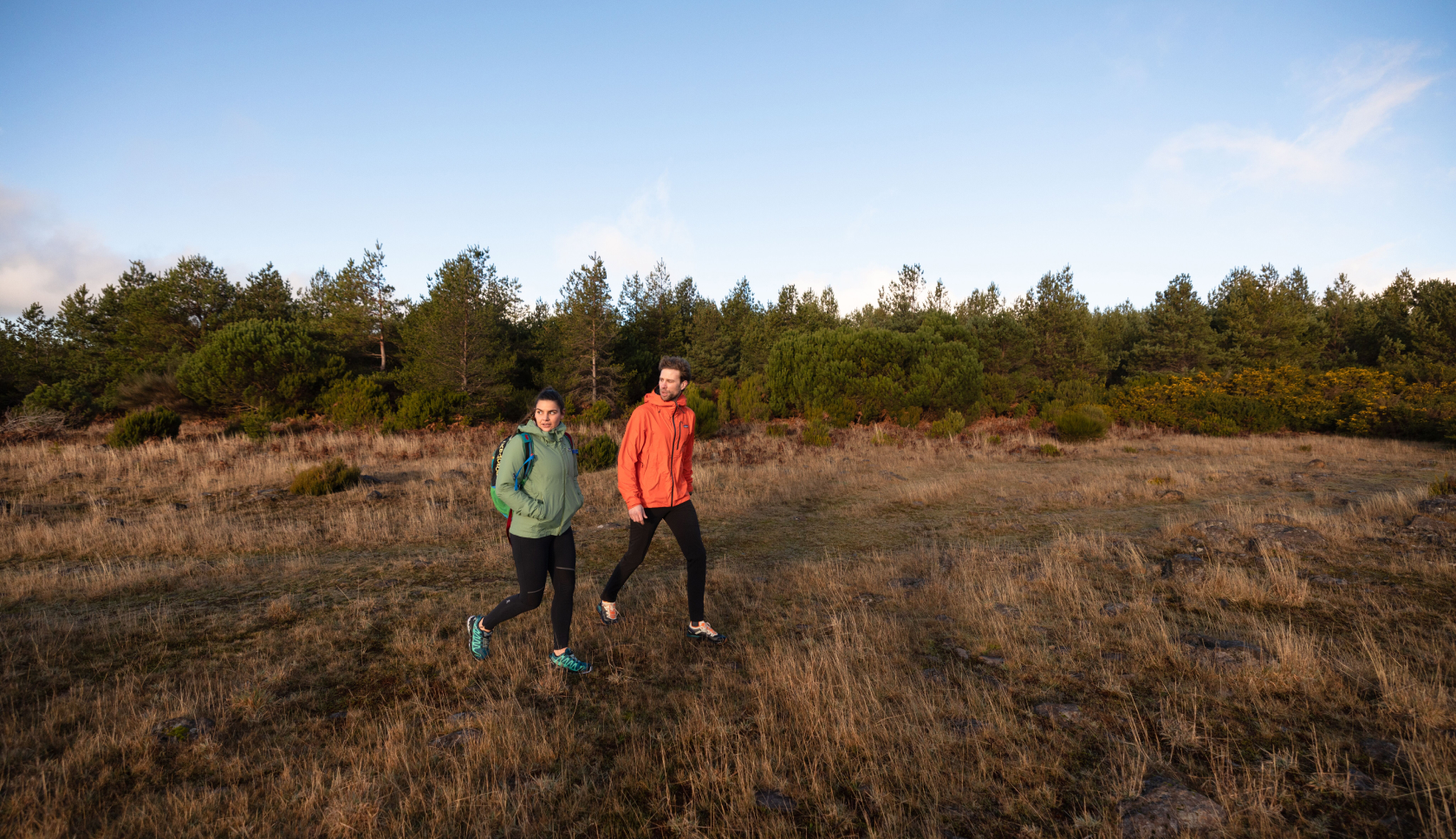 Een man en vrouw wandelen in Brabant door een open veld