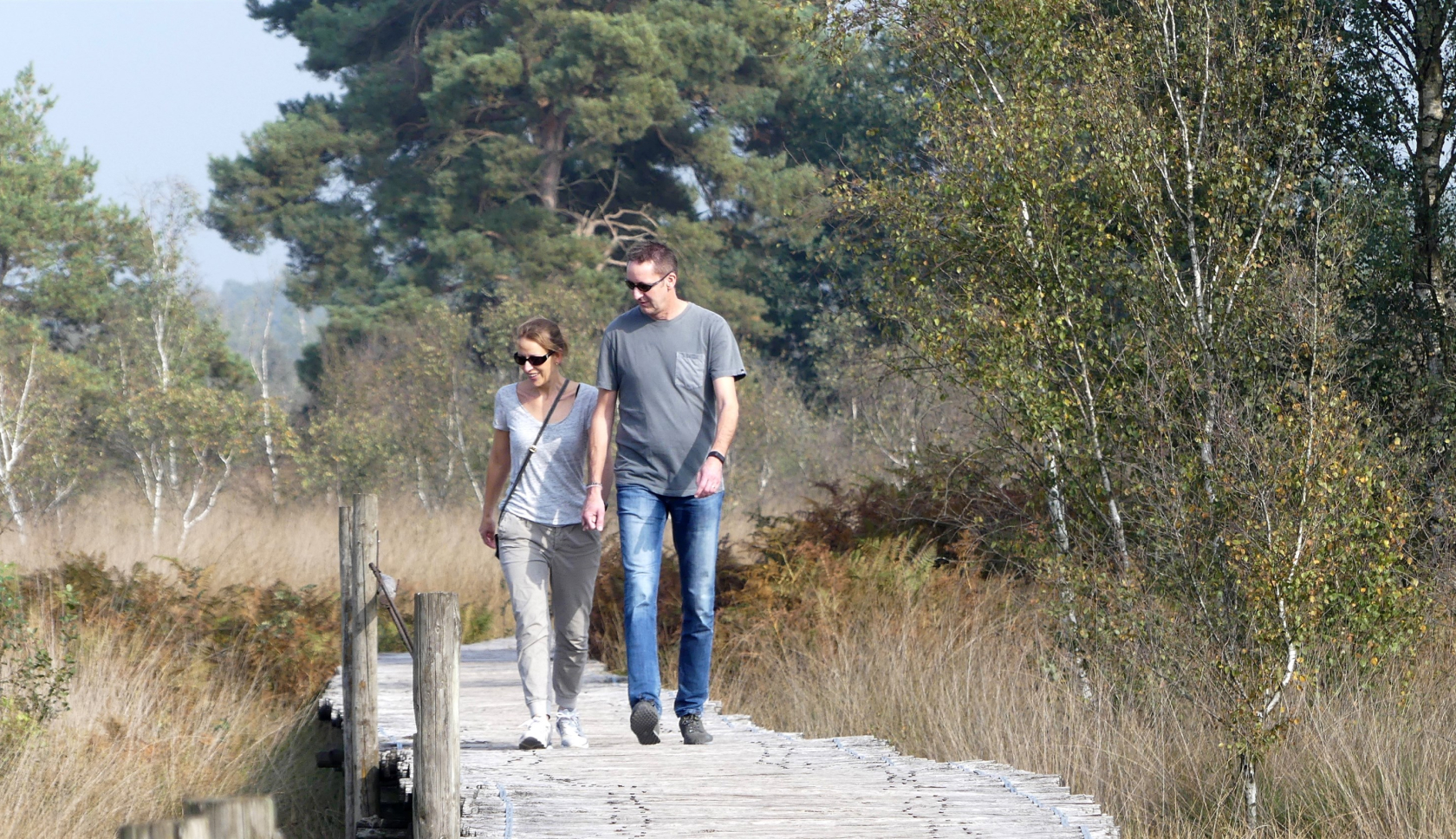 Een man en een vrouw lopen over een vlonder.
