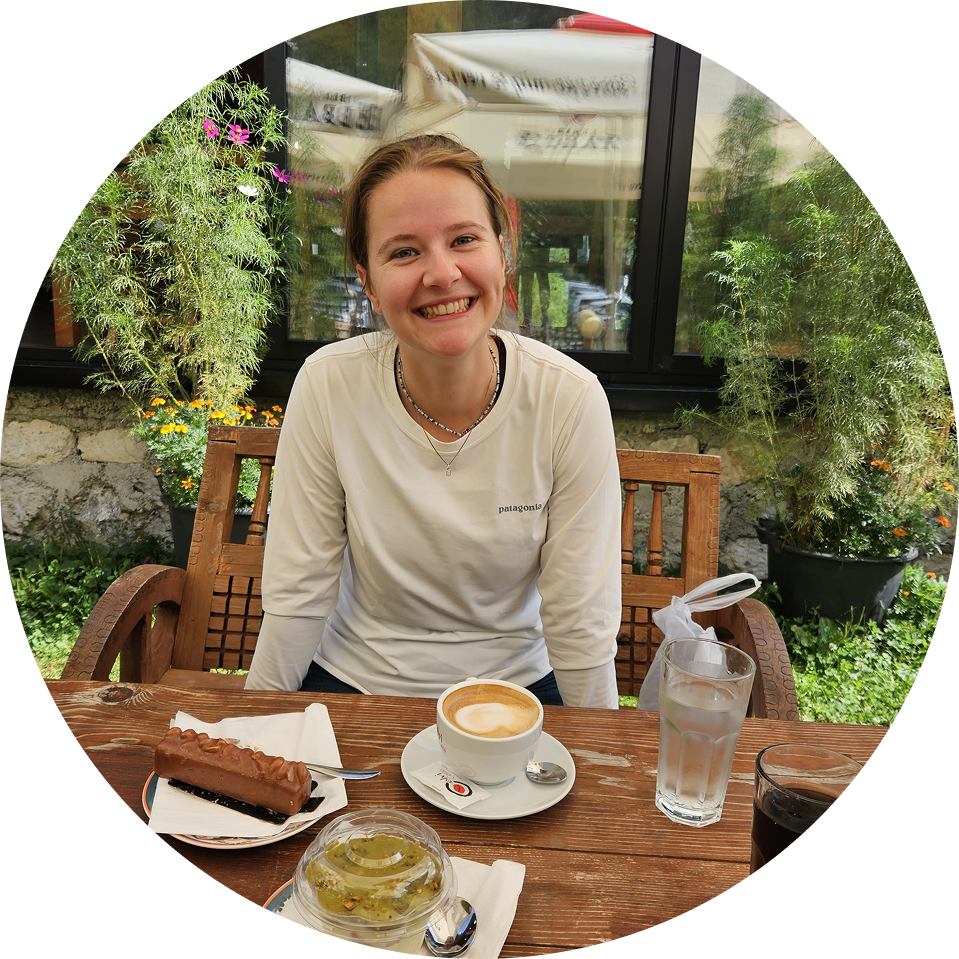Een meisje lacht in de camera met koffie voor zich