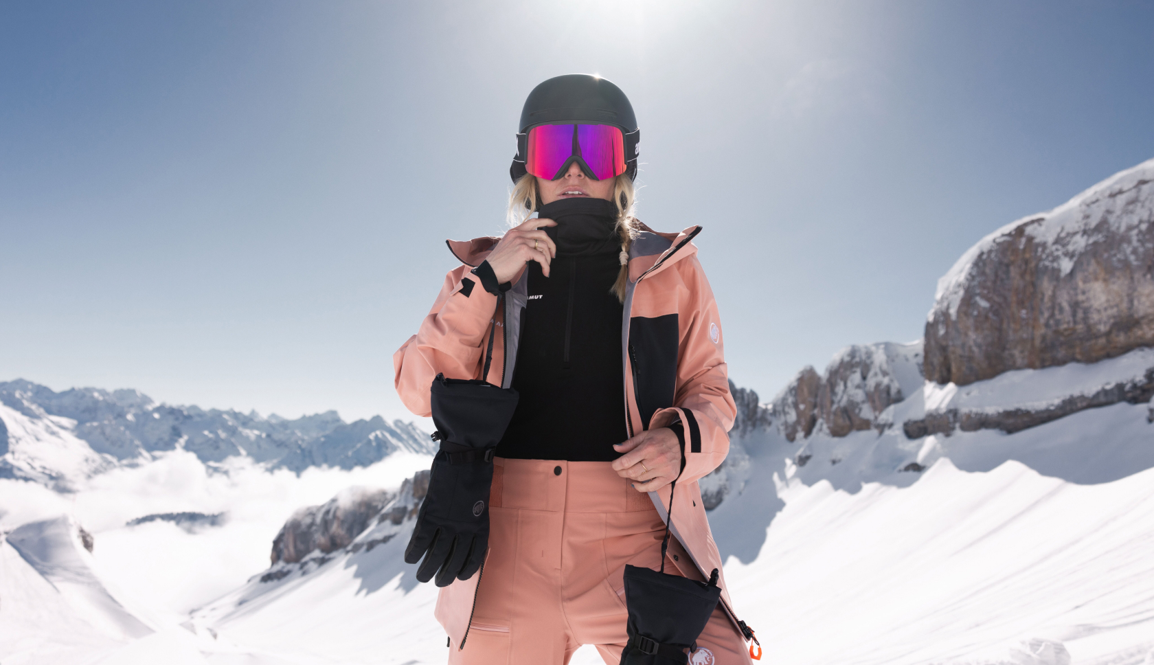 vrouw in een roze ski-pak staat op de piste