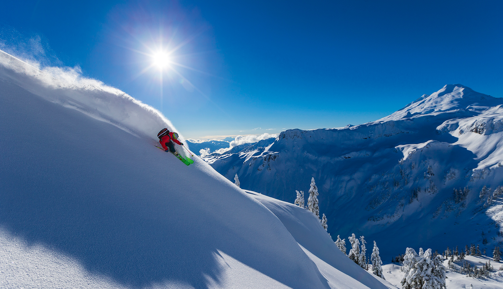 man gaat met groen snowboard van de berg af