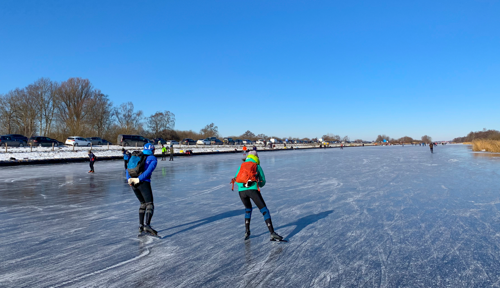 twee mensen schaatsen over natuurijs