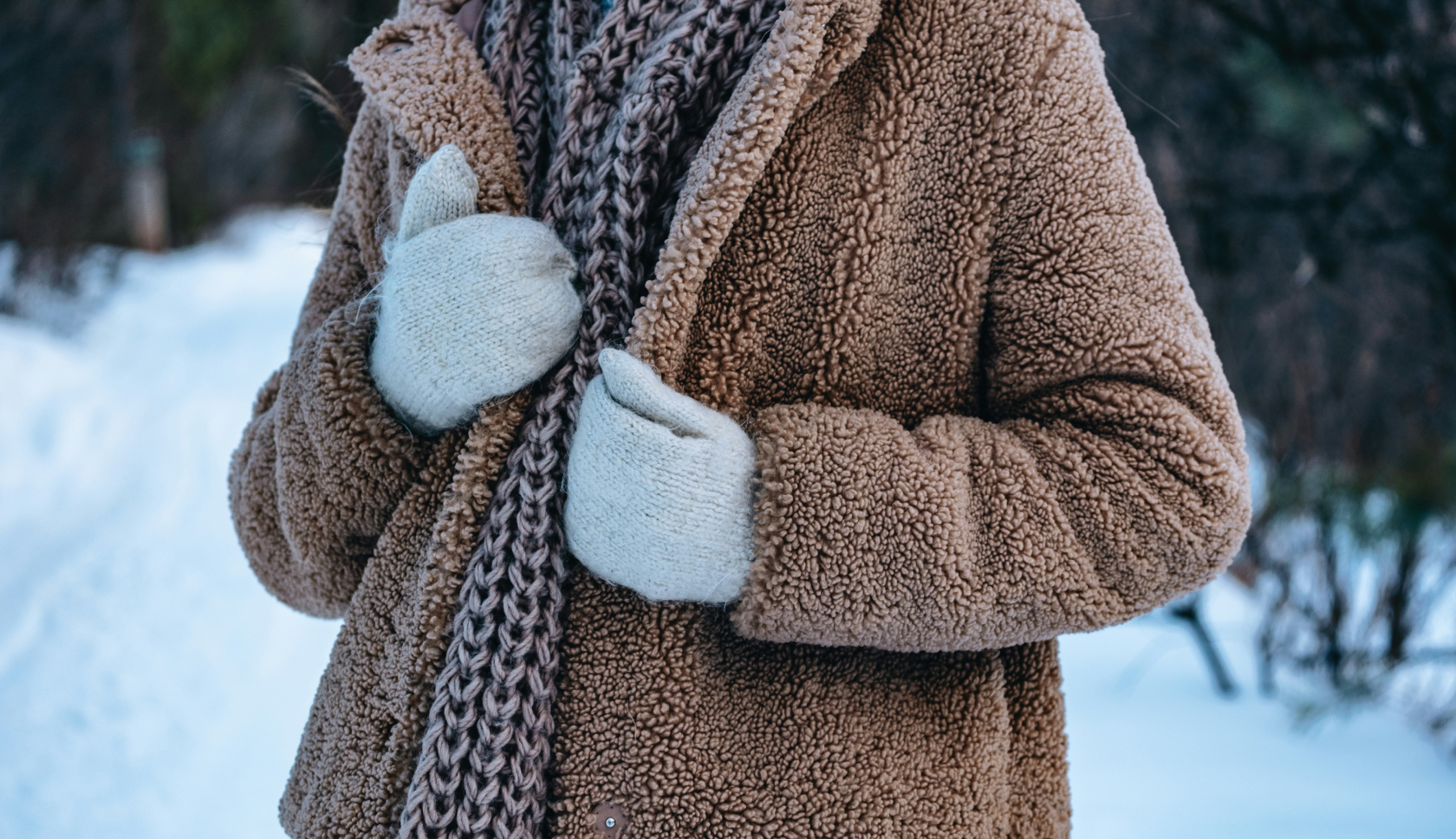 Vrouw draagt warme wollen kleding in een sneeuwlandschap.