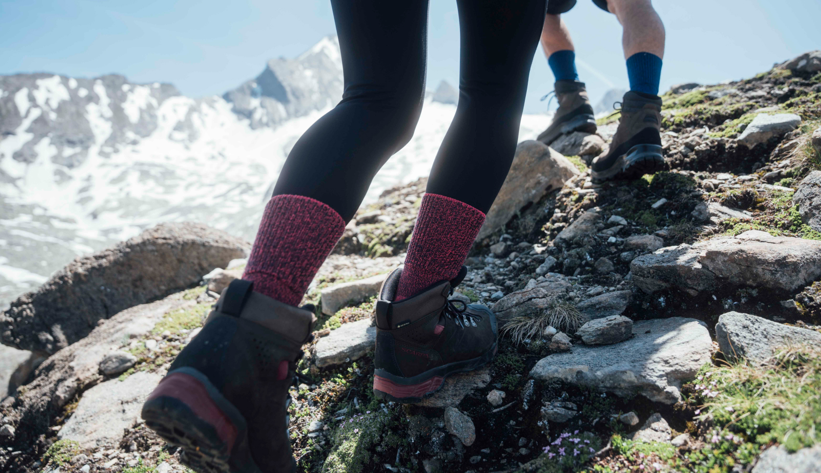 Twee mensen wandelen met stevige wandelschoenen door de bergen. 