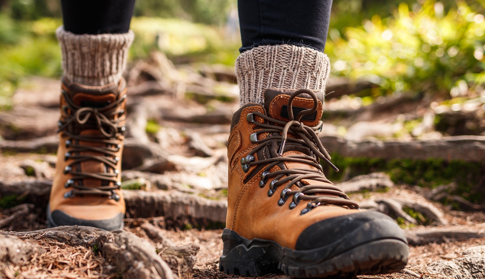 Wandelschoenen met dikke sokken op een bosrijk wandelpad.