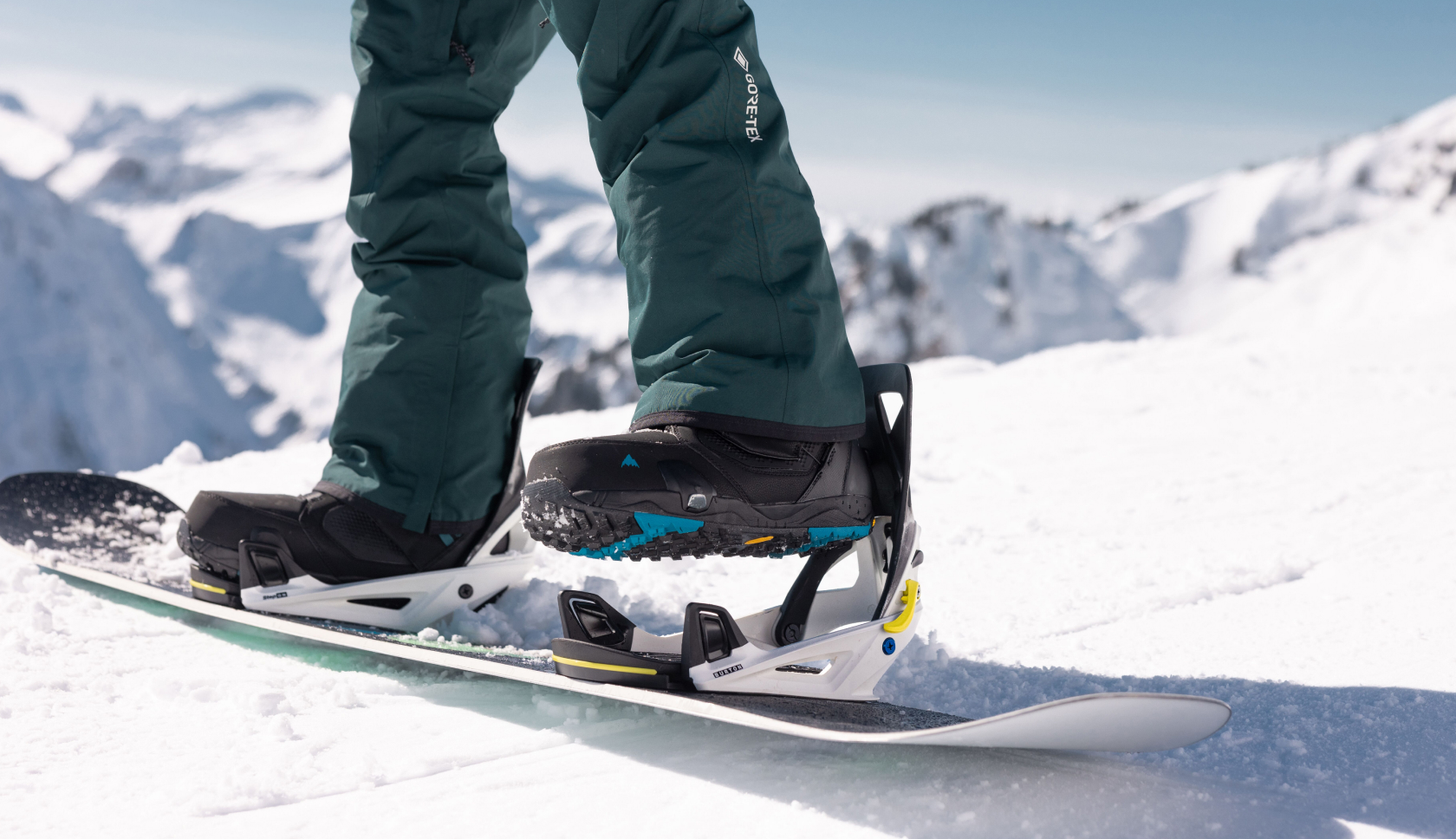 man klikt zijn sneeuwschoen op zijn sneeuwbord op een witte piste