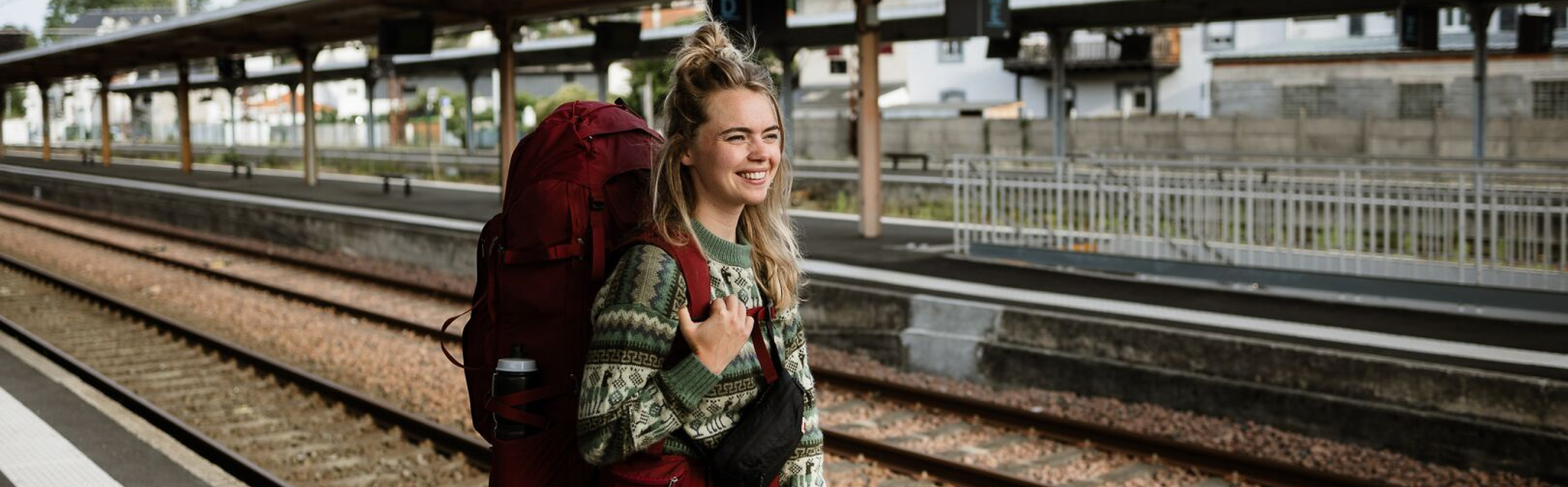meid staat te wachten op de trein met backpack op