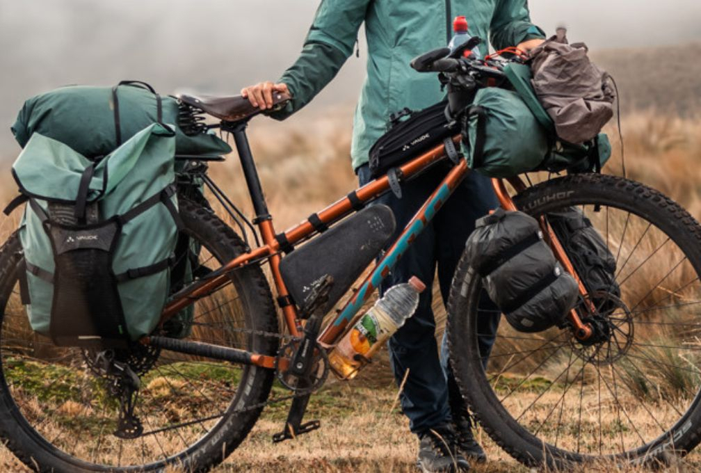 sportieve oranje fiets met fietstassen staat in een vergeeld veld