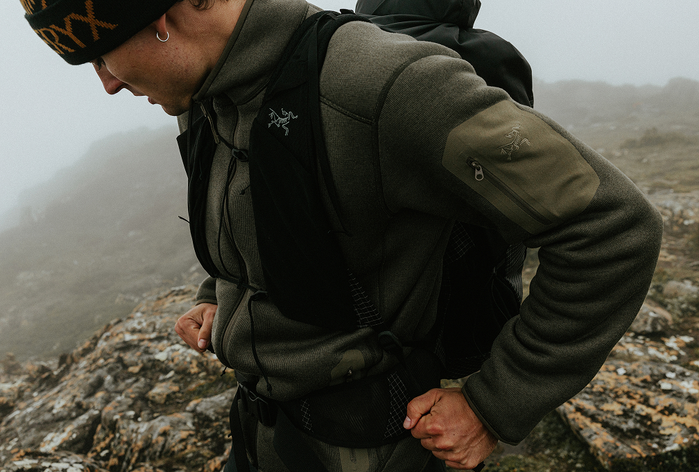 Man in Arc’teryx wandelkleding met rugzak in de bergen