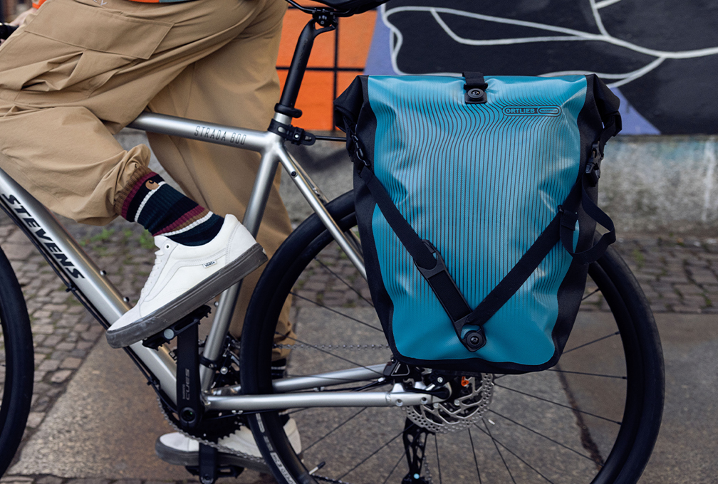 Blauwe Ortlieb fietstas aan de bagagedrager van een fiets