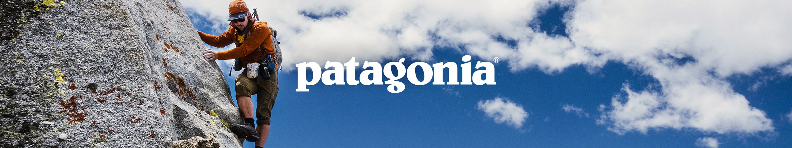 Klimmer in Patagonia-outdoorkleding beklimt een steile rotswand, met het Patagonia-logo in beeld.