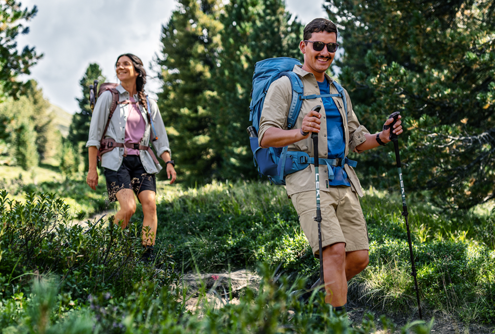 Twee wandelaars lopen door een bosrijke omgeving.