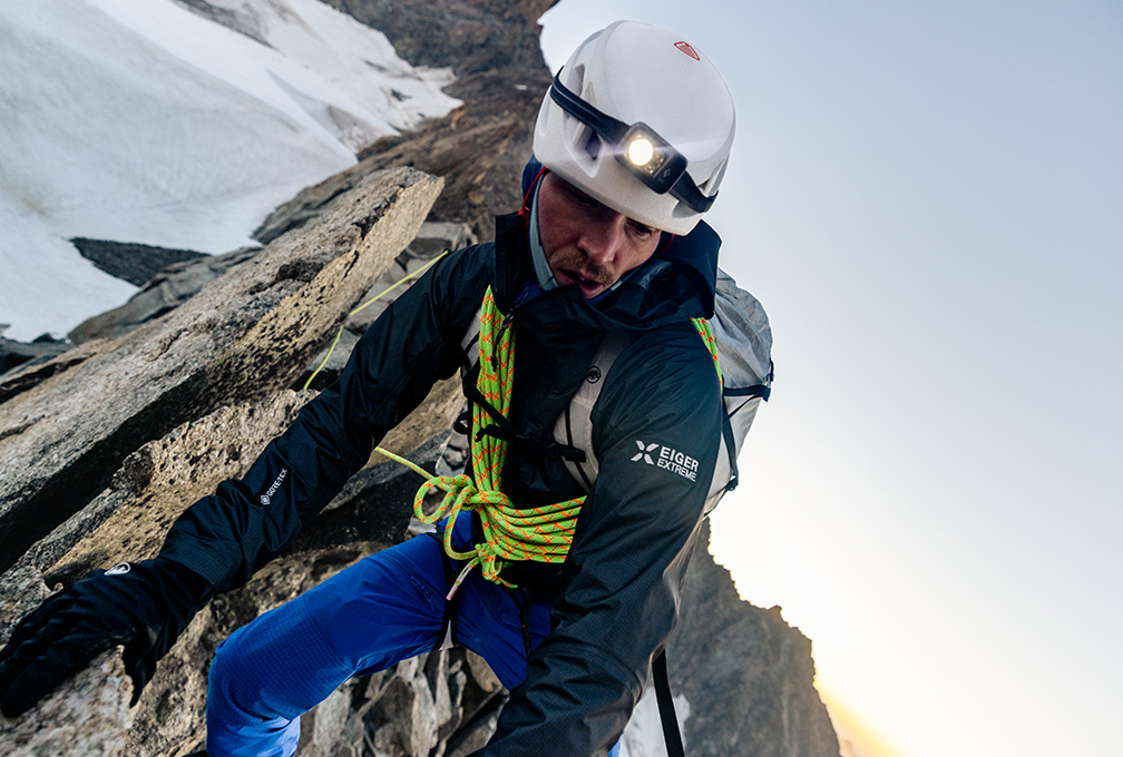 man in klimuitrusting rust op een besneeuwde berg