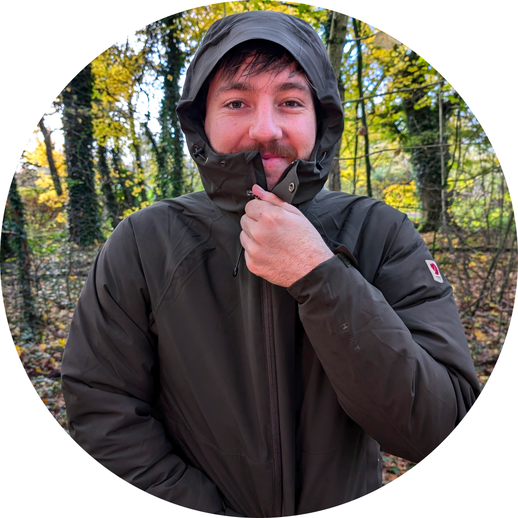 Jongen ritst jas dicht in bos
